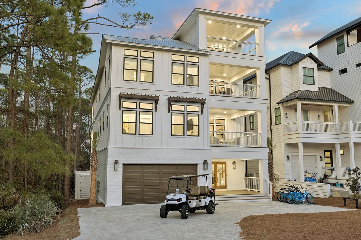 Front of a coastal home at dusk. Home designed by Jason Mundy.
