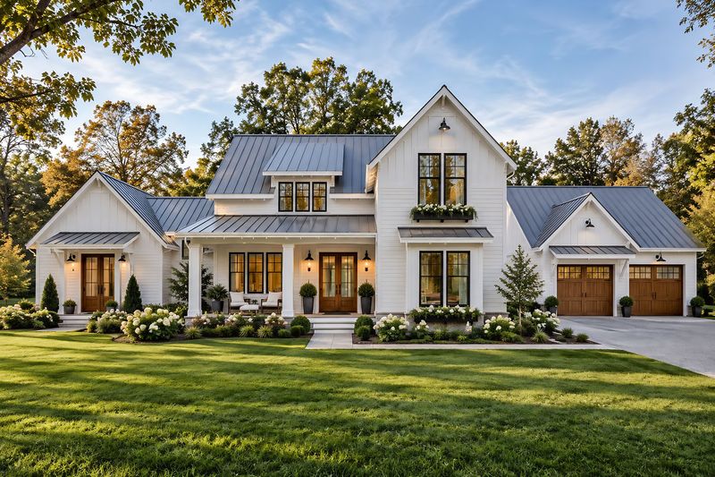 Photorealistic rendering of a white board-and-batten modern farmhouse in golden-hour light with standing-seam metal roofs, wood front doors, carriage-style garage doors and hydrangea beds.